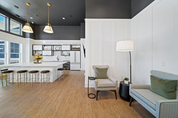 A modern kitchen with a bar area and a living room area.